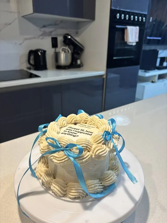Sweet 16 cake with cream rosettes and blue ribbon