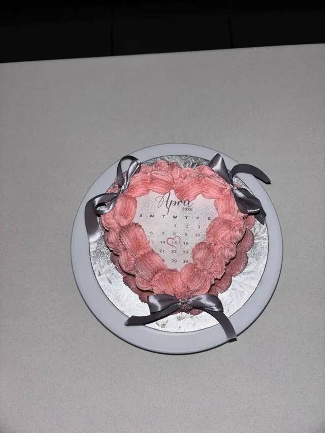 Pink glitter heart-shaped cake with calendar topper