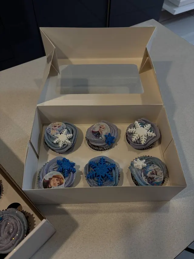 Frozen-themed cupcakes with snowflakes in a box