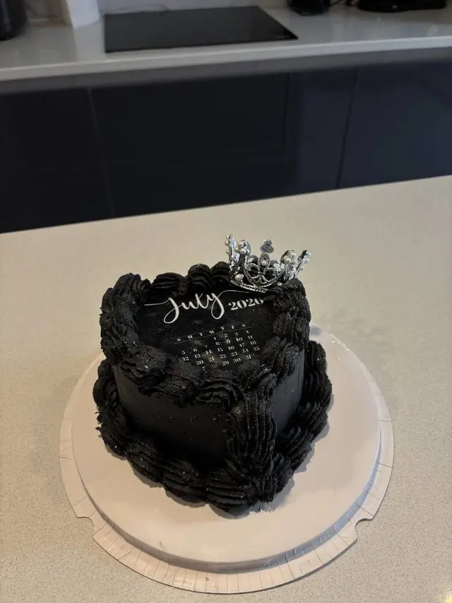 Black glitter heart cake with a crown topper