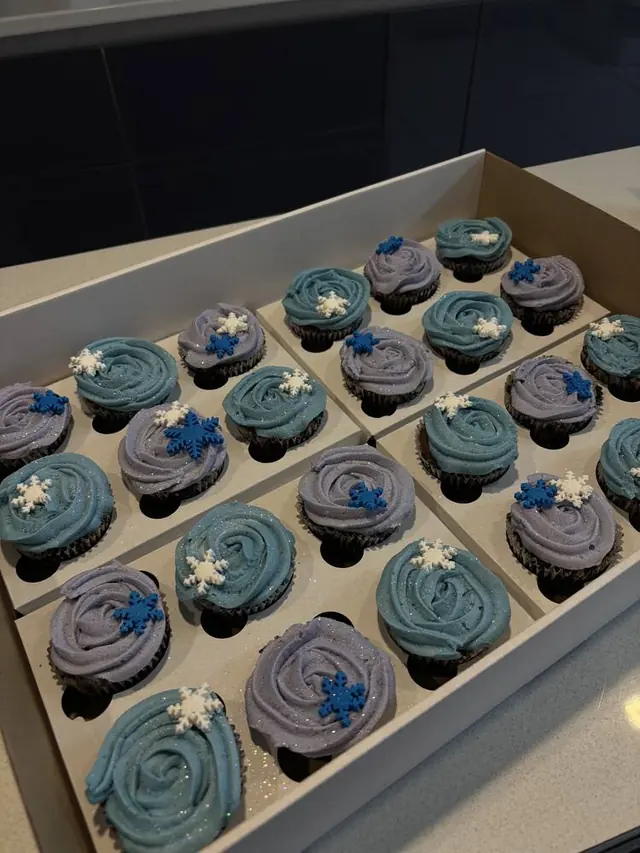 Box of blue and lilac glitter rosette cupcakes