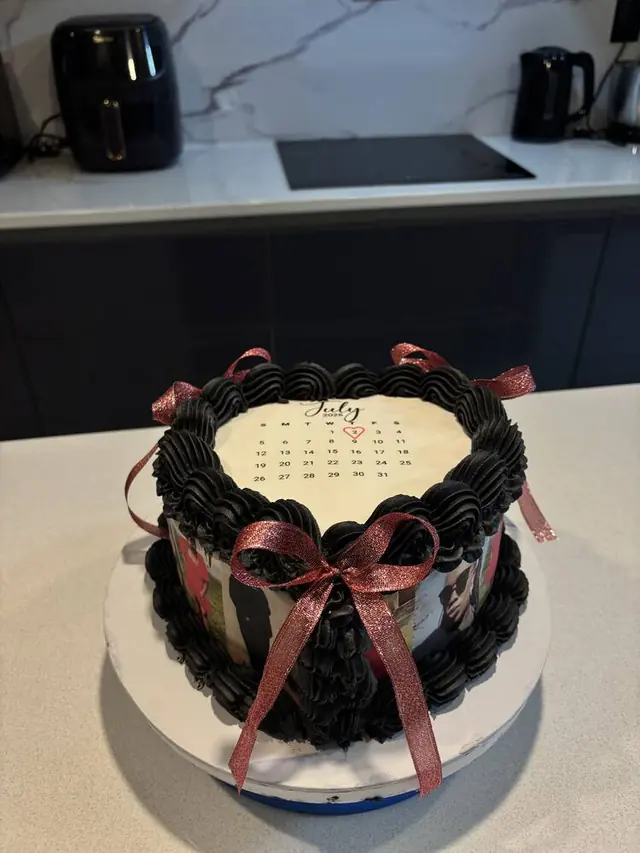 Black heart cake with photo strip and pink ribbon