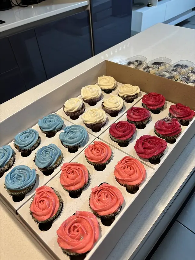 Assorted rosette cupcakes in blue, cream, coral and red