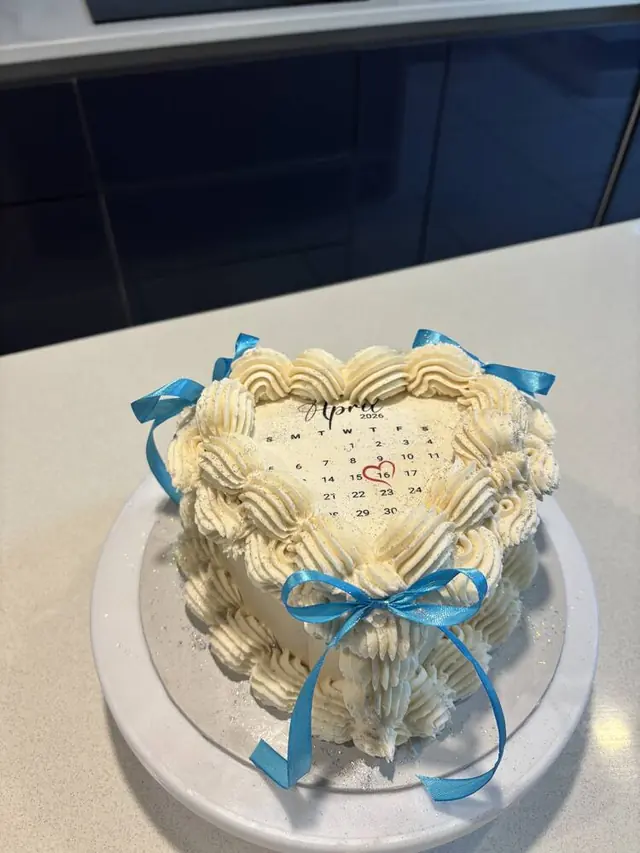 Cream heart cake with blue ribbon and calendar design