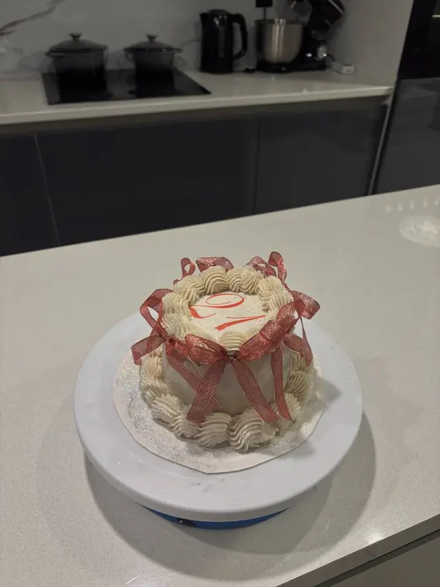 Cream cake with red ribbon and glitter finish