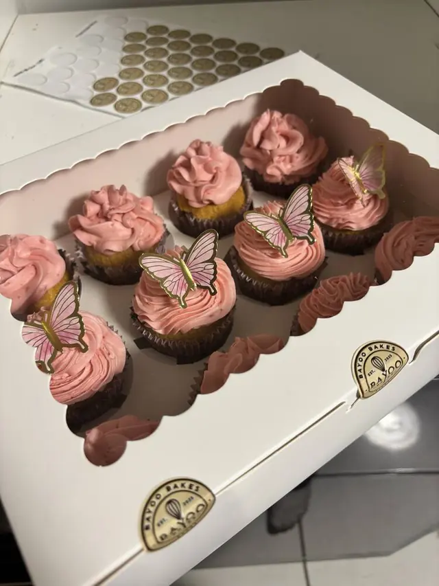 Pink butterfly-topped cupcakes in a Bayoo Bakes box